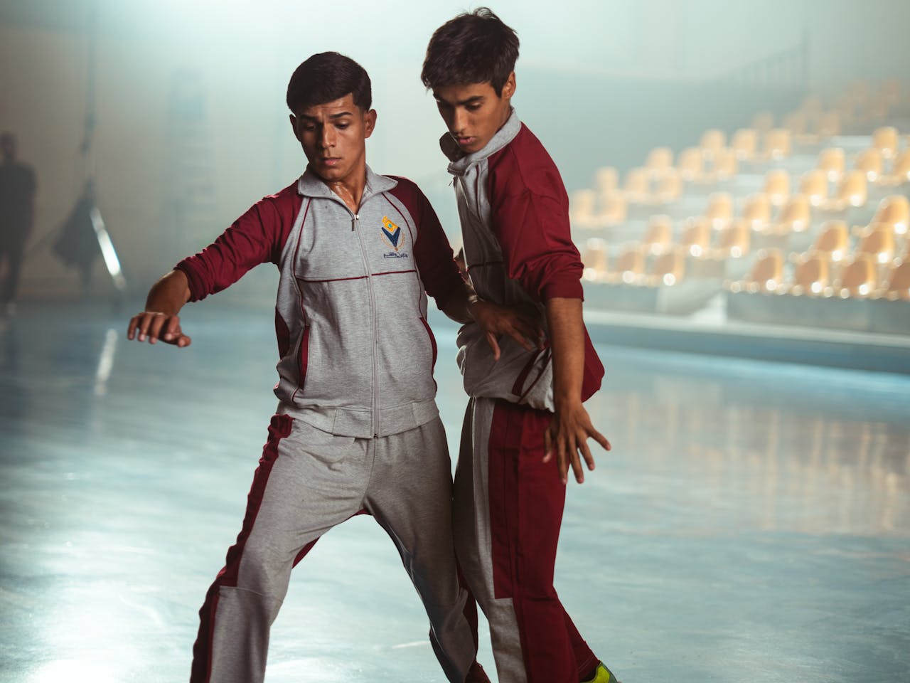 Two young athletes in a gymnasium practicing moves, captured in Baghdad, Iraq.