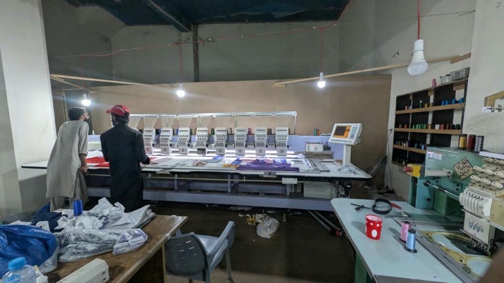 Multi-head embroidery machine running a production order at Ravix Pro Industry clothing factory in Daska, Sialkot, Pakistan