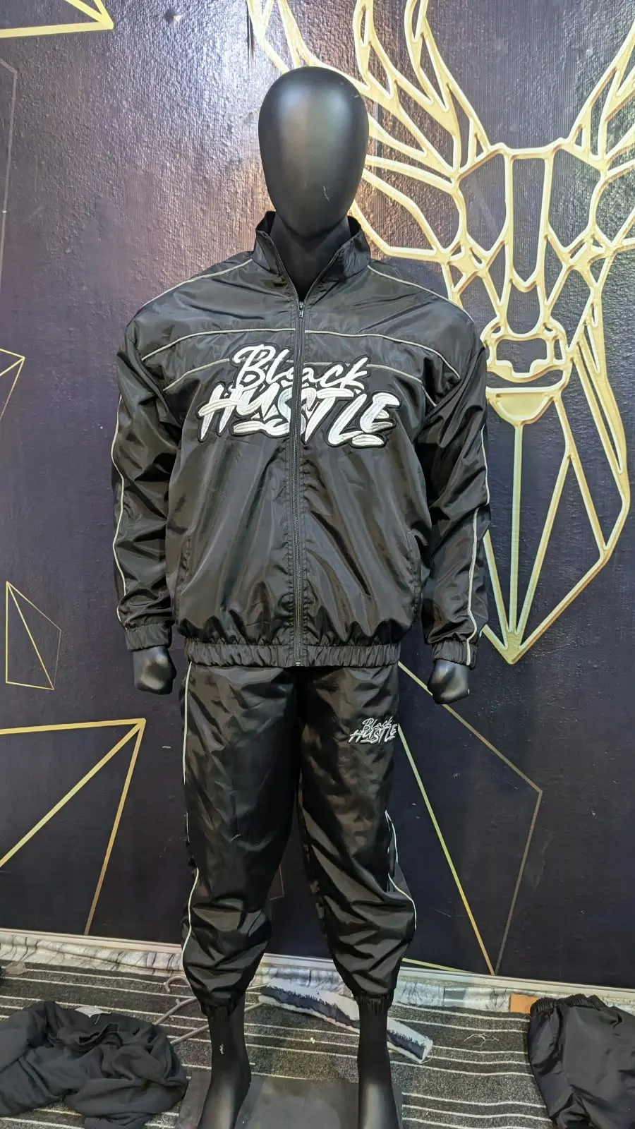 Custom black windbreaker jacket and pants set made by Ravix Pro Industry clothing manufacturer in Sialkot, Pakistan