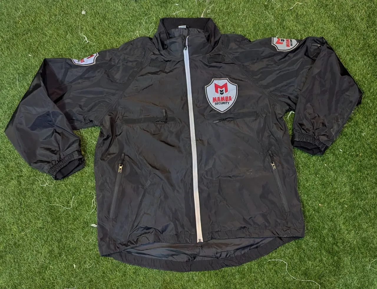 Custom black softshell jacket with chest badge made by Ravix Pro Industry clothing manufacturer in Sialkot, Pakistan