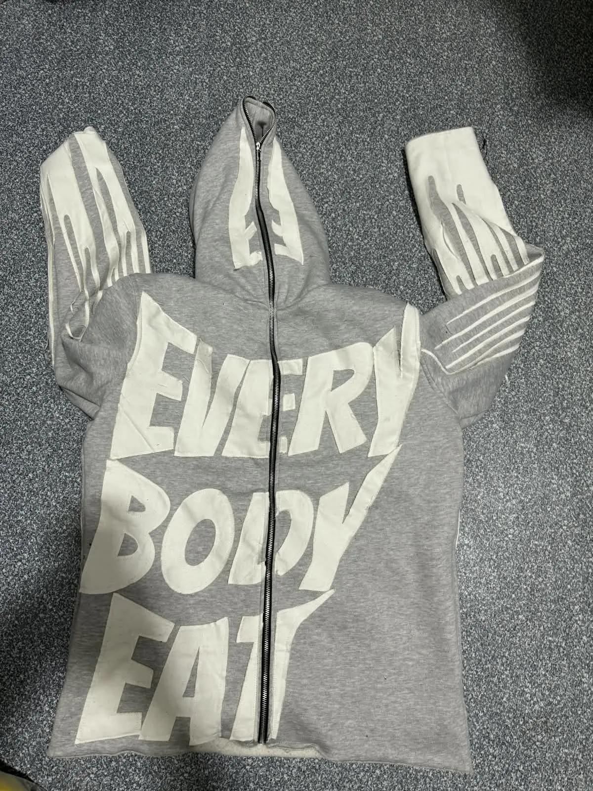 Custom grey full-zip hoodie with puff print lettering made by Ravix Pro Industry clothing manufacturer in Sialkot, Pakistan