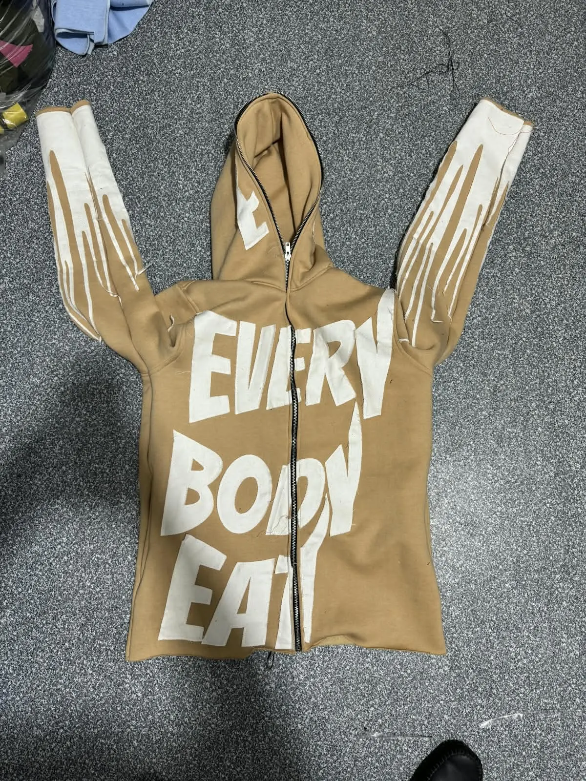 Custom tan full-zip hoodie with puff print lettering made by Ravix Pro Industry clothing manufacturer in Sialkot, Pakistan
