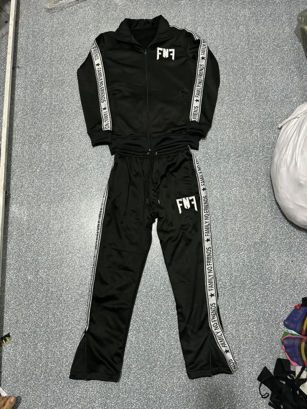 Custom black tracksuit with side taping made by Ravix Pro Industry clothing manufacturer in Sialkot, Pakistan