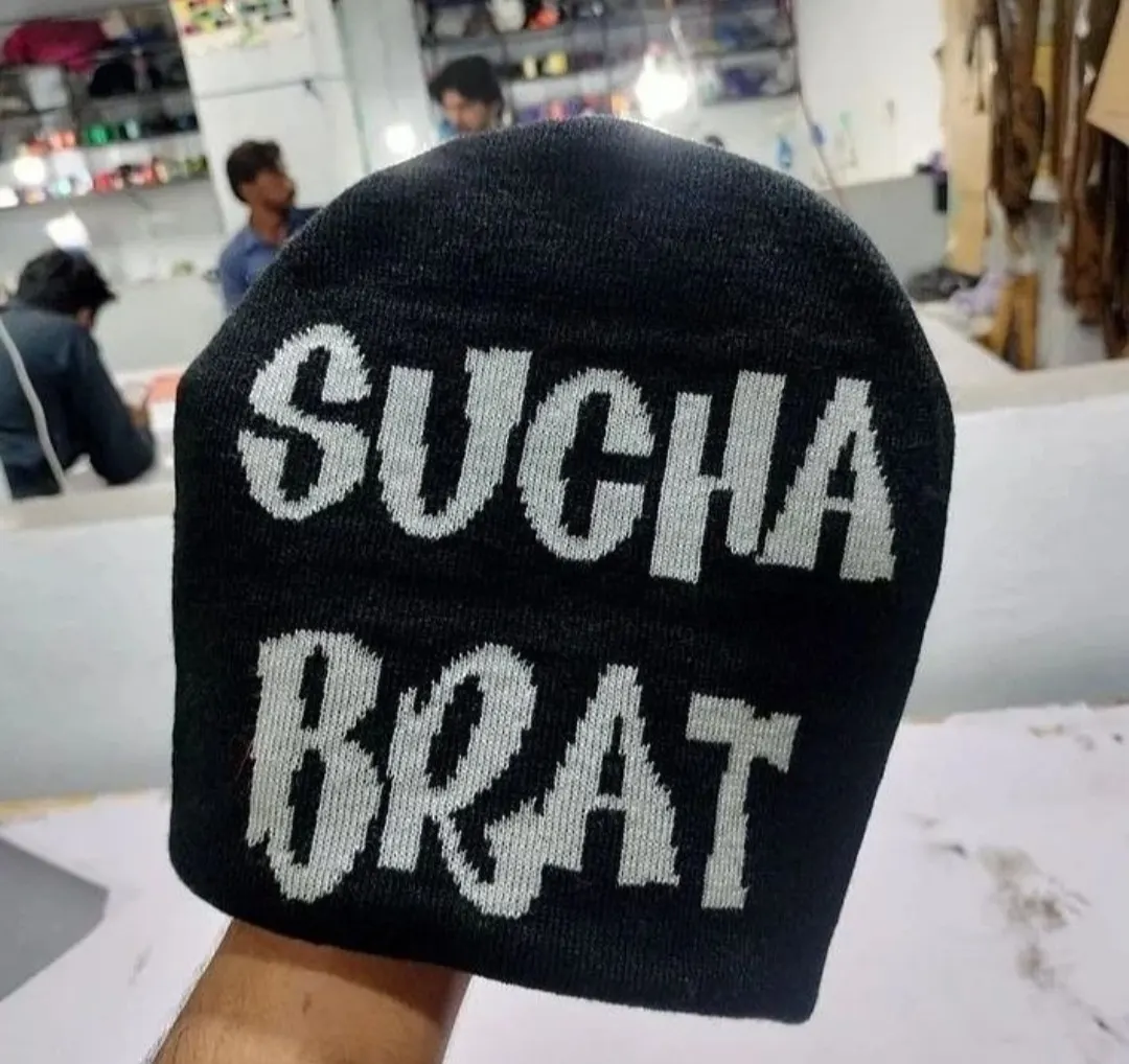 Custom black knitted beanie with jacquard lettering made by Ravix Pro Industry clothing manufacturer in Sialkot, Pakistan